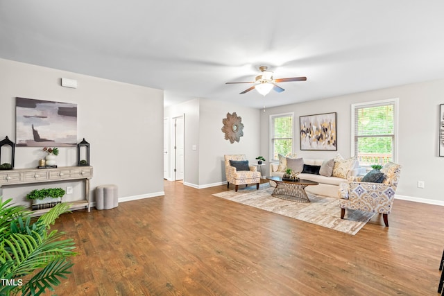 living room with baseboards, ceiling fan, and wood finished floors