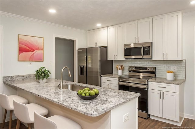 1016 Martindale Dr, Fayetteville, NC 28304 - kitchen featuring a kitchen bar, ornamental molding, stainless steel appliances, and a sink
