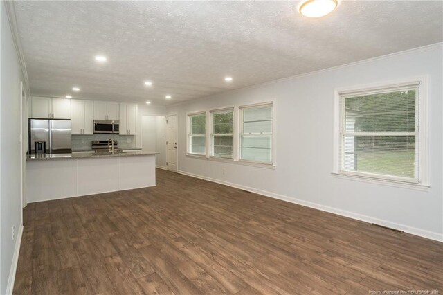 1016 Martindale Dr, Fayetteville, NC 28304 - unfurnished living room with a sink, a textured ceiling, ornamental molding, and dark wood-style flooring