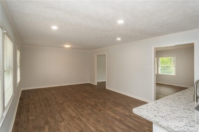 1016 Martindale Dr, Fayetteville, NC 28304 - unfurnished living room featuring a textured ceiling, ornamental molding, and dark wood-style flooring