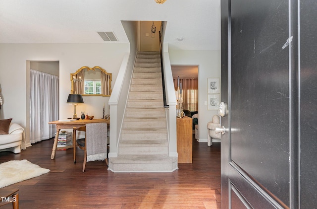 stairs featuring baseboards, wood finished floors, and visible vents
