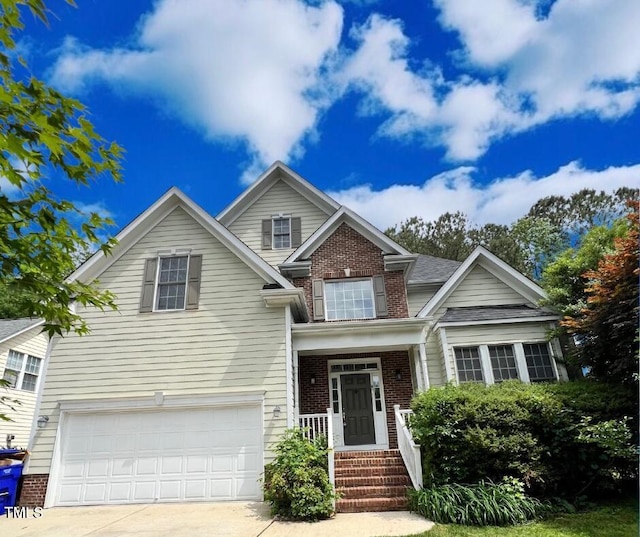 craftsman house featuring concrete driveway, a garage, and brick siding