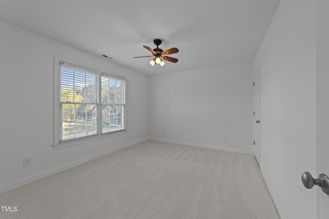 unfurnished room featuring ceiling fan, visible vents, baseboards, and light carpet