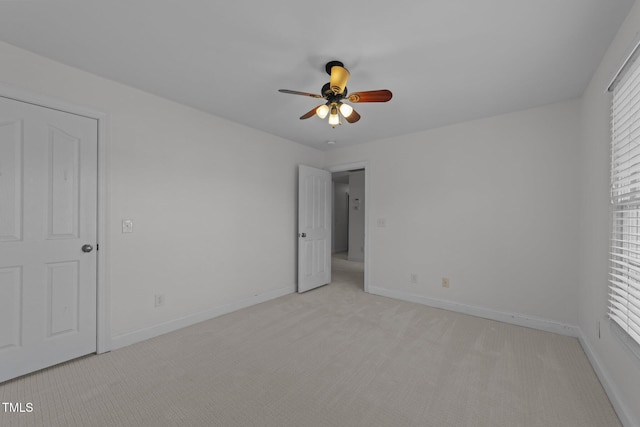 unfurnished bedroom featuring light colored carpet, baseboards, and a ceiling fan