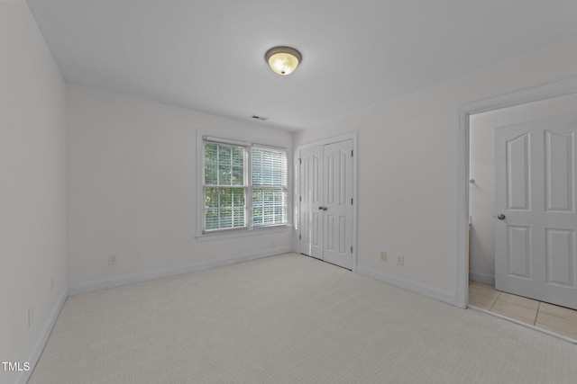 unfurnished bedroom featuring carpet, a closet, and baseboards