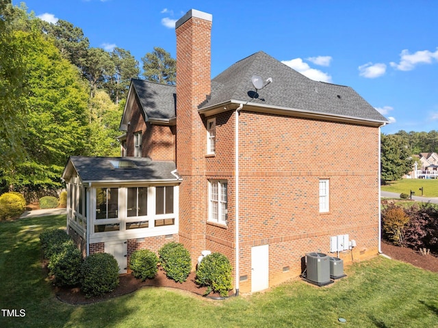 back of property featuring brick siding, a sunroom, and a chimney
