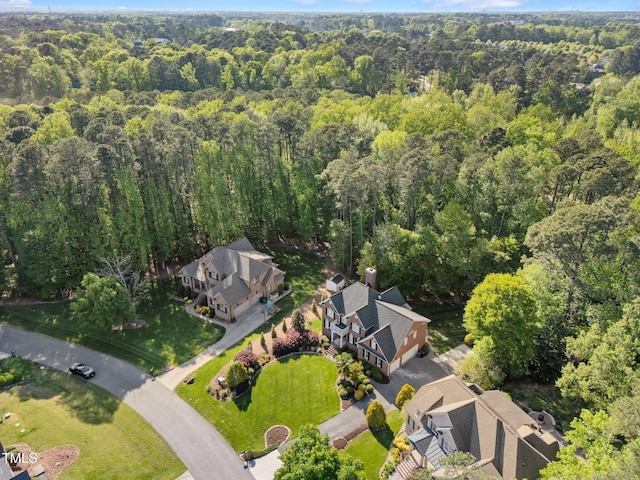 bird's eye view with a wooded view