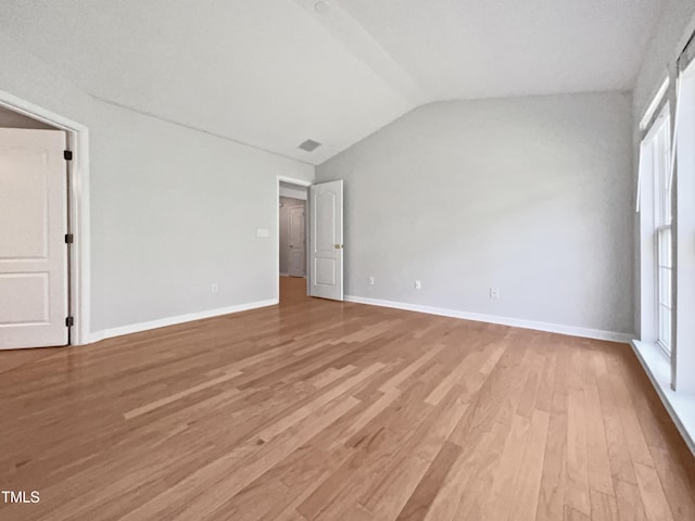 107 Kinship Ln, Apex, NC 27502 - unfurnished bedroom featuring light wood finished floors, vaulted ceiling, baseboards, and multiple windows