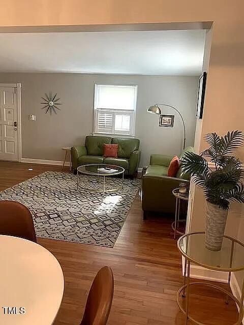 living area with baseboards and wood finished floors