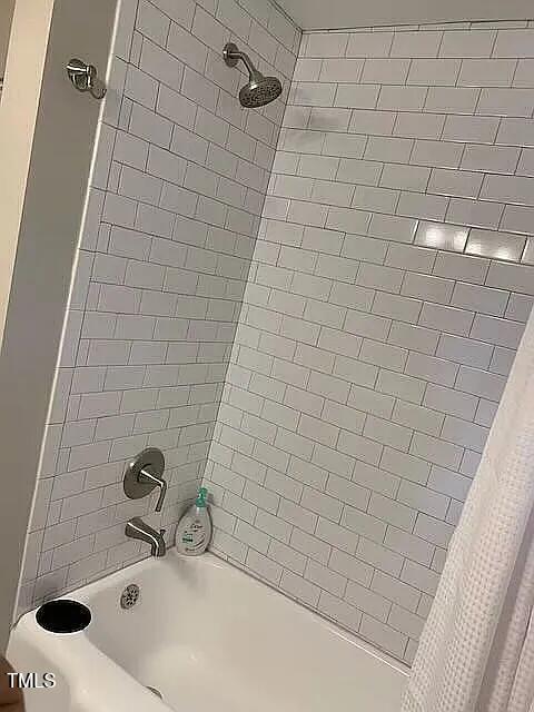 bathroom with shower / tub combo with curtain