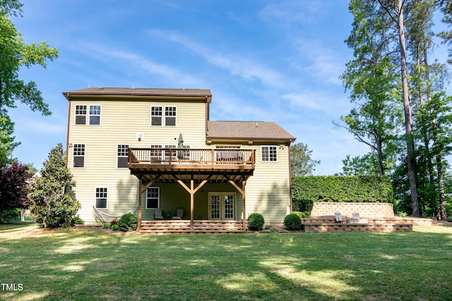 rear view of property with a lawn, a deck, and french doors