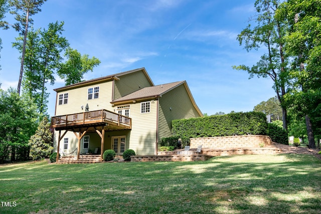 rear view of property with french doors, a wooden deck, and a yard
