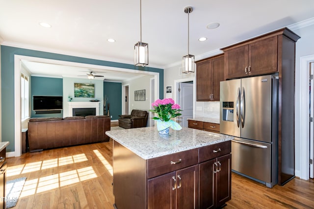 kitchen with stainless steel refrigerator with ice dispenser, light wood finished floors, crown molding, and ceiling fan