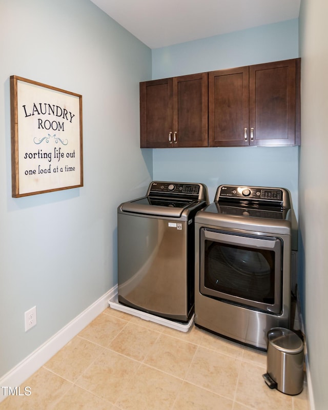 laundry room featuring cabinet space, baseboards, and washing machine and clothes dryer