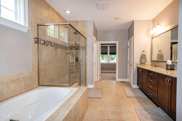 bathroom with double vanity, a sink, a garden tub, and a stall shower