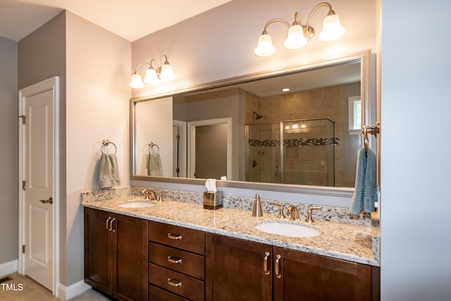 full bathroom featuring double vanity, a shower stall, a sink, and tile patterned flooring