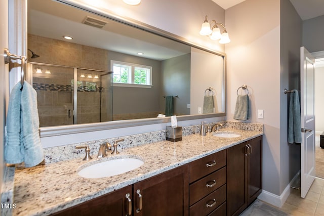 bathroom with a sink, tile patterned floors, a shower stall, and double vanity