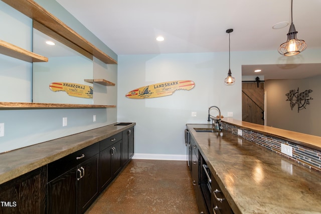 bar featuring recessed lighting, baseboards, a barn door, and a sink