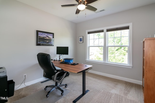 office space featuring visible vents, baseboards, ceiling fan, and light colored carpet