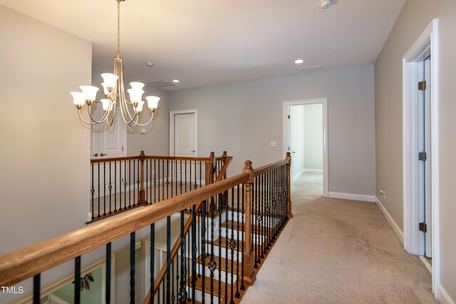 hall featuring an inviting chandelier, light carpet, recessed lighting, baseboards, and an upstairs landing