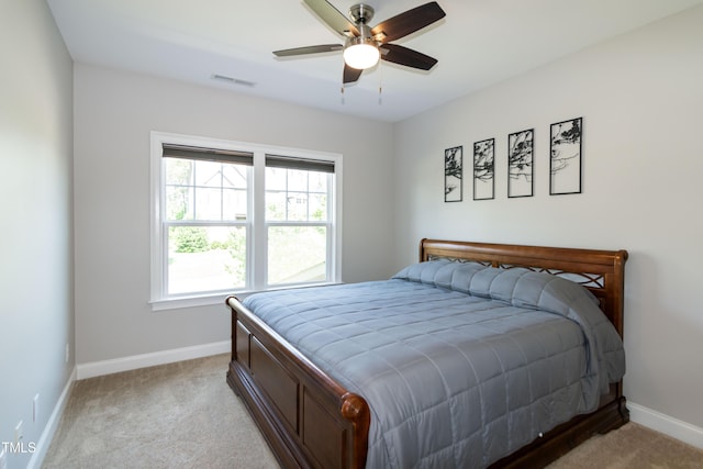bedroom with visible vents, baseboards, ceiling fan, and light colored carpet