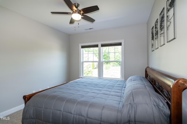 carpeted bedroom with baseboards, a ceiling fan, and visible vents