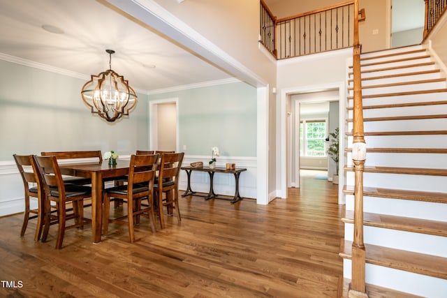 1820 Yates Wheel Way, Raleigh, NC 27606 - dining room with stairs, ornamental molding, a chandelier, wood finished floors, and a wainscoted wall