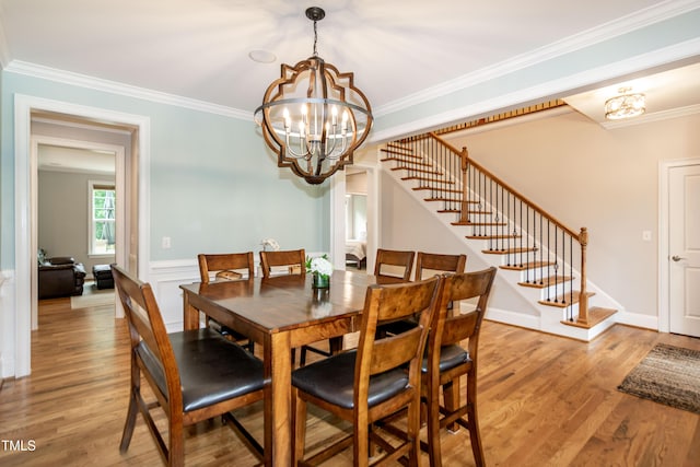 1820 Yates Wheel Way, Raleigh, NC 27606 - dining room featuring a chandelier, stairs, light wood-style floors, ornamental molding, and a wainscoted wall