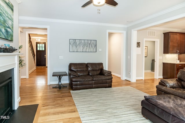 1820 Yates Wheel Way, Raleigh, NC 27606 - living area with a ceiling fan, light wood-type flooring, a fireplace with flush hearth, crown molding, and baseboards