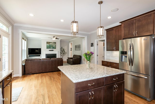 1820 Yates Wheel Way, Raleigh, NC 27606 - kitchen featuring stainless steel fridge, a fireplace, crown molding, light wood-style flooring, and light stone counters