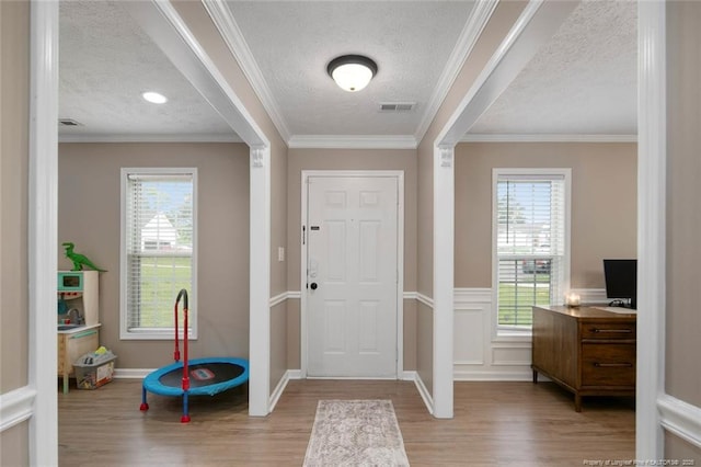 119 Woodbine Dr, Raeford, NC 28376 - entrance foyer featuring wood finished floors, a textured ceiling, plenty of natural light, and ornamental molding