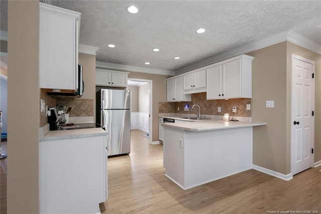119 Woodbine Dr, Raeford, NC 28376 - kitchen with stainless steel appliances, crown molding, a sink, light countertops, and a peninsula