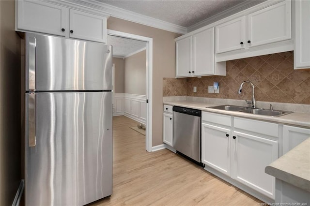 119 Woodbine Dr, Raeford, NC 28376 - kitchen with appliances with stainless steel finishes, a sink, light countertops, ornamental molding, and white cabinets