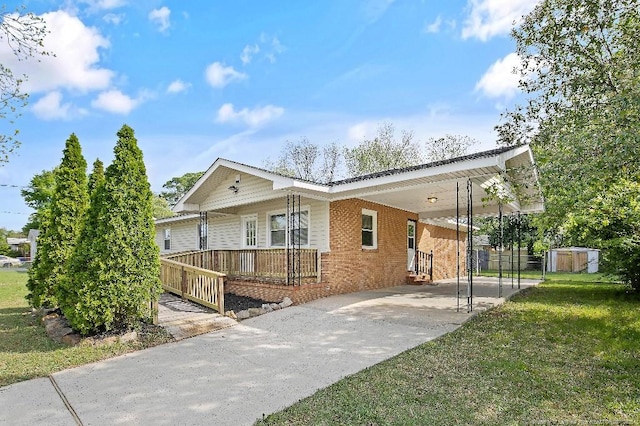 single story home featuring a storage shed, an outbuilding, a front lawn, a carport, and driveway