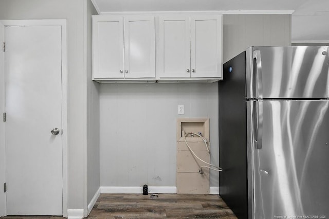 clothes washing area with baseboards, wood finished floors, laundry area, and washer hookup