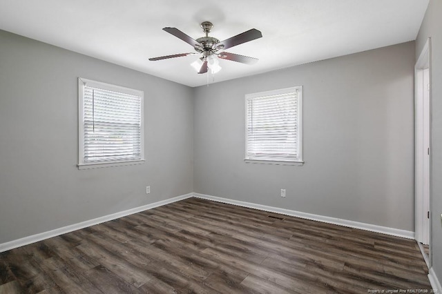 spare room with ceiling fan, baseboards, and dark wood-style flooring