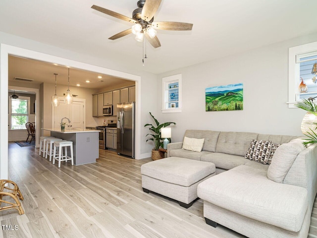 living area featuring ceiling fan, light wood finished floors, baseboards, visible vents, and recessed lighting