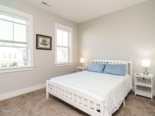 carpeted bedroom with baseboards, multiple windows, and visible vents