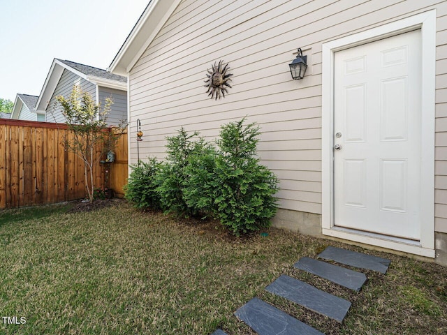 entrance to property with a lawn and fence