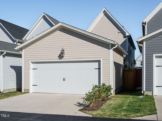 view of front of home featuring an attached garage, driveway, and fence