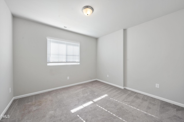 unfurnished room featuring carpet, visible vents, and baseboards