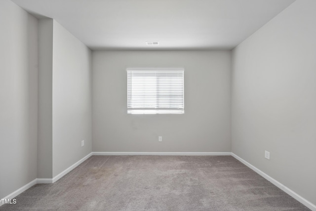 spare room with visible vents, carpet flooring, and baseboards