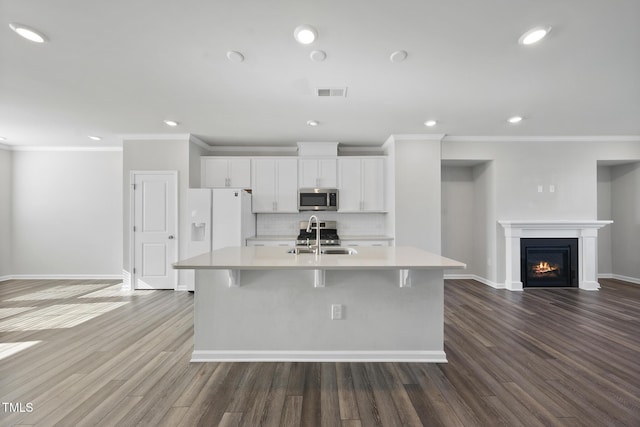 kitchen featuring visible vents, crown molding, stainless steel appliances, and a sink