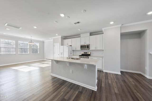 kitchen featuring stainless steel appliances, visible vents, and ornamental molding