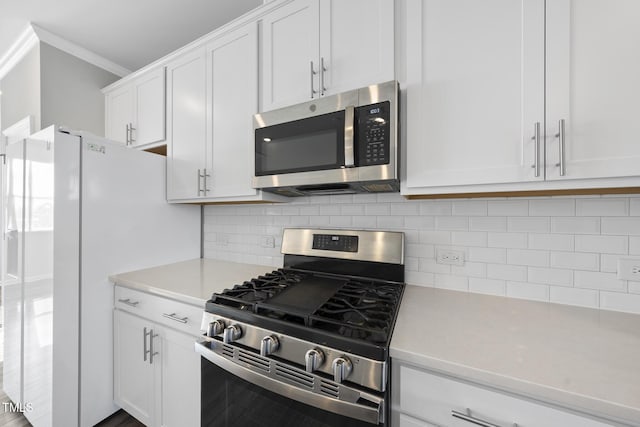 kitchen with stainless steel appliances, light countertops, crown molding, tasteful backsplash, and white cabinetry