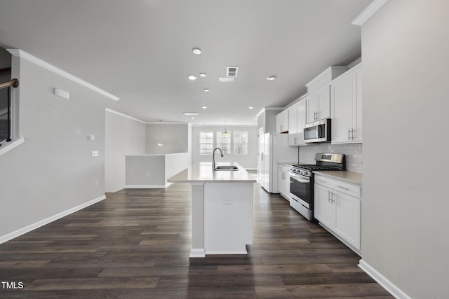kitchen featuring recessed lighting, an island with sink, a sink, crown molding, and appliances with stainless steel finishes