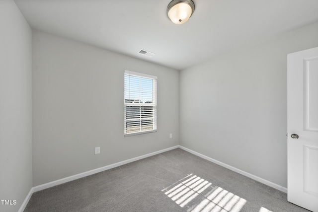 empty room featuring visible vents, carpet flooring, and baseboards