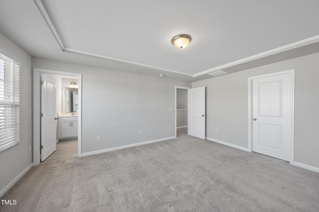 unfurnished bedroom featuring baseboards, light carpet, and connected bathroom