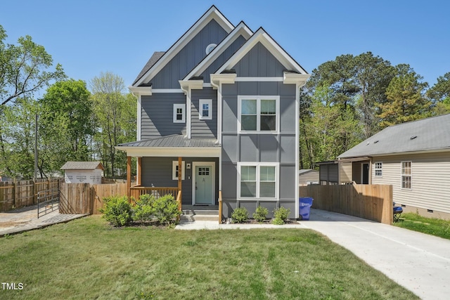 view of front of property with a front lawn, fence, a porch, and board and batten siding