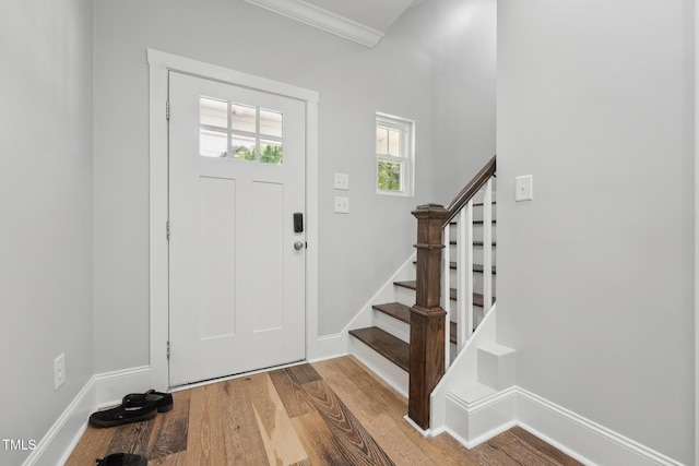 entrance foyer with baseboards, wood finished floors, and stairs